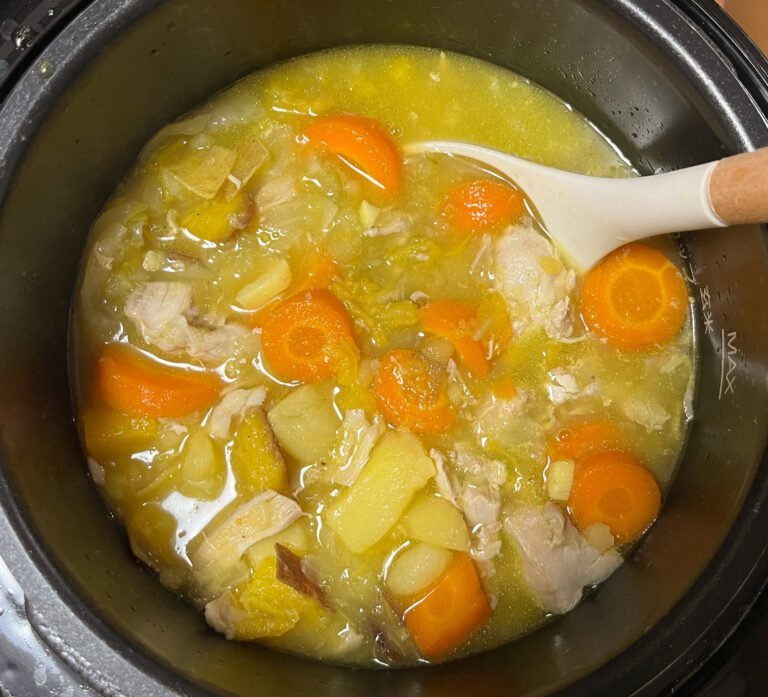 easy chicken soup in a pressure cooker. carrots, potatoes, and chicken float in a golden broth.